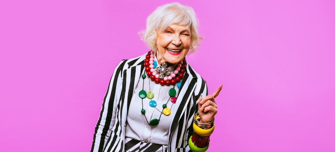 An Elderly Woman Winking on a Pink Background